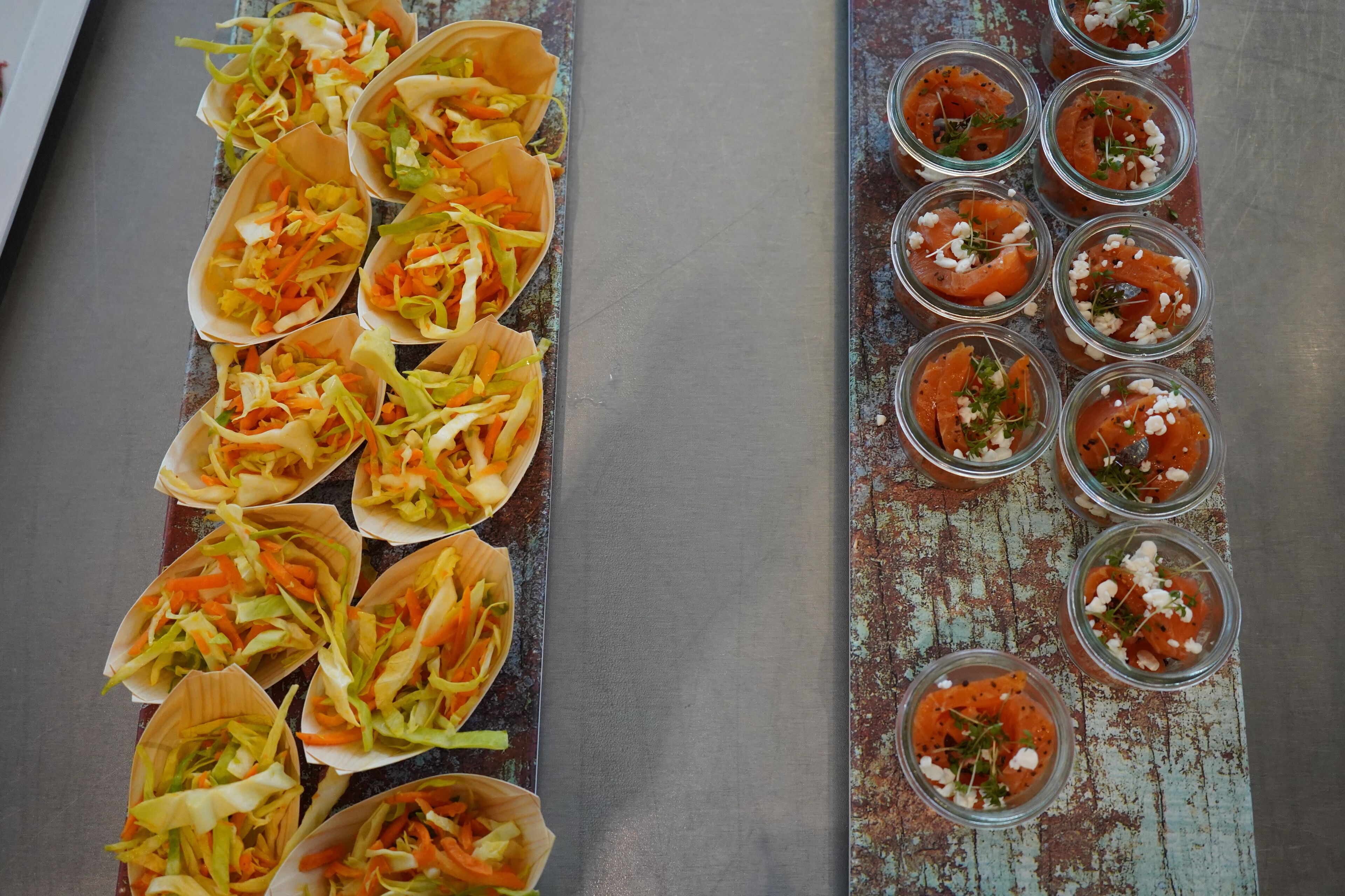 A table with food items, including tacos and small bowls with a red sauce and white topping.