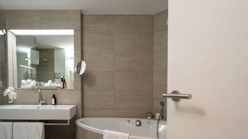 A bathroom with a sink, mirror, and bathtub.