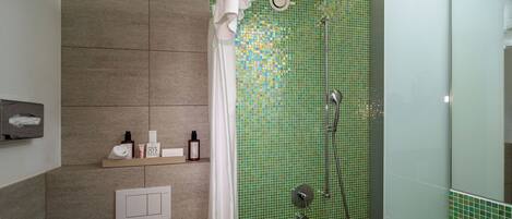 Un baño moderno con ducha, toallero y estante con artículos de aseo.