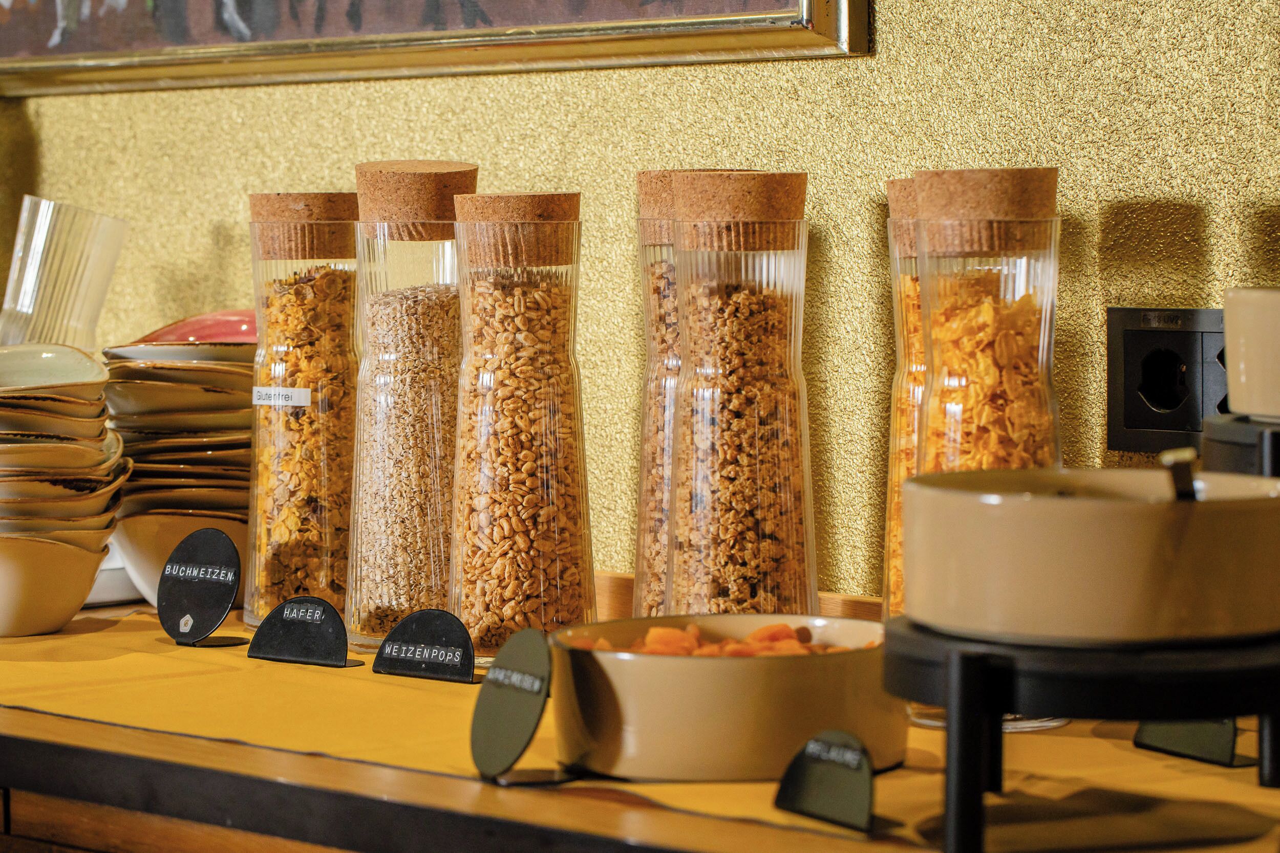 Un área de bufé con recipientes etiquetados de diversos alimentos.