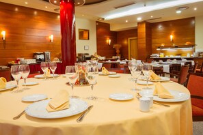 A dining area with round tables set for a meal, featuring white plates, wine glasses, and napkins. - Hotel Bardo Recoletos Coco (Salamanca)