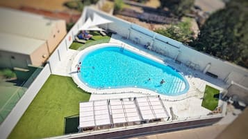 Una piscina al aire libre de temporada, sillones reclinables de piscina