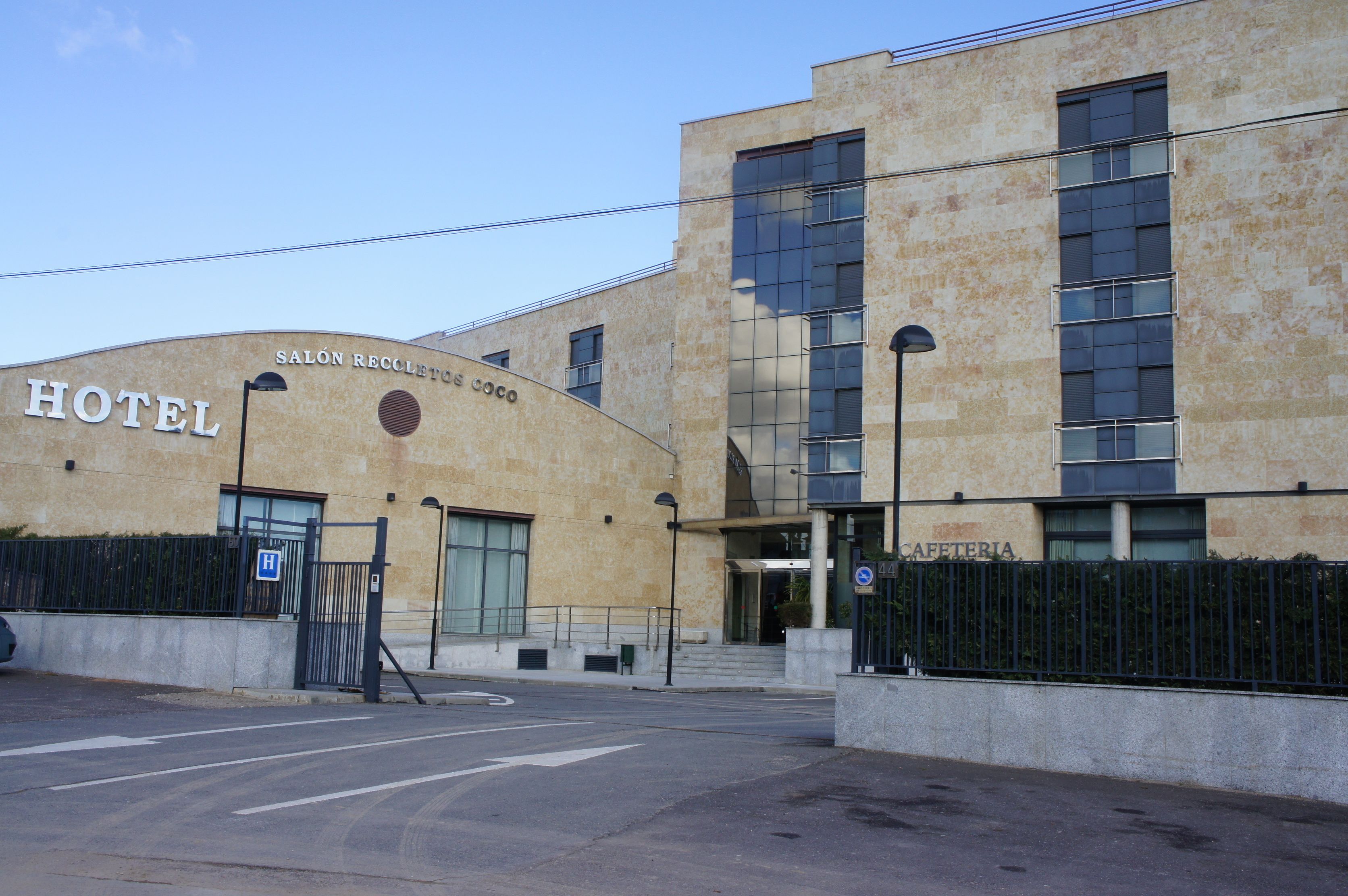 A hotel with a curved facade, a sign reading "SALÓN RECOLETOS COCO," and a visible entrance.
