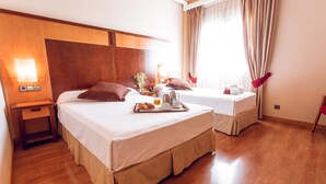 A hotel room with two beds, wooden headboards, a nightstand, a tray with breakfast items, and a window with curtains. - Hotel Bardo Recoletos Coco (Salamanca)