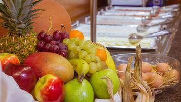 A fruit and egg display with a variety of fruits including apples, grapes, oranges, and a pineapple.