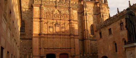 Un edificio histórico con detalles arquitectónicos intrincados, incluyendo una amplia entrada en arco y una cúpula destacada.