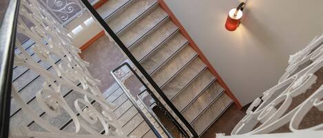 A staircase with ornate white railings and a wall-mounted light fixture.