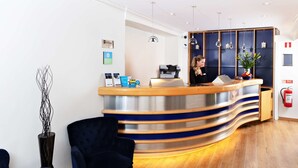 Un comptoir d’accueil au design moderne, un réceptionniste et un extincteur fixés au mur.