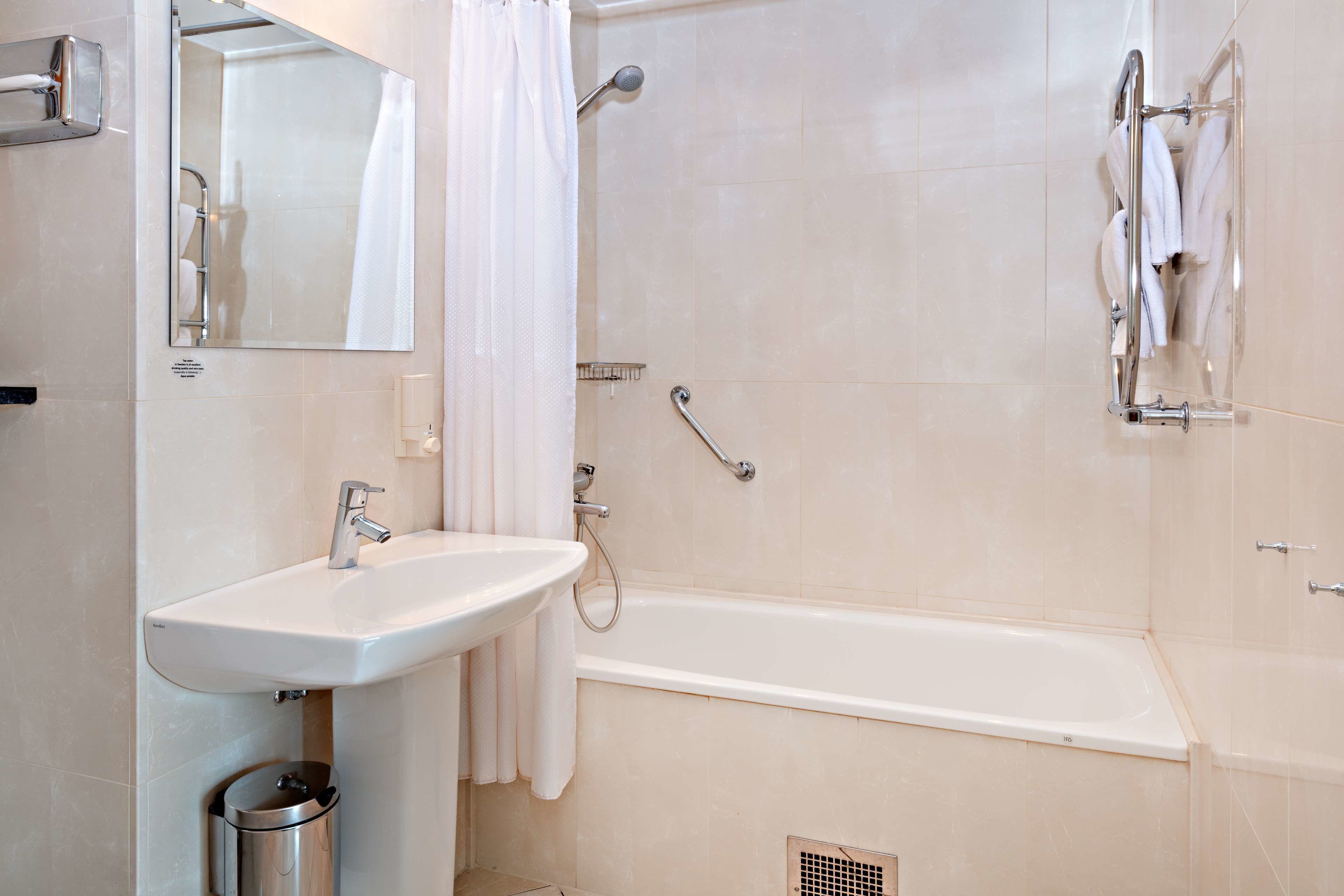 Une salle de bain moderne équipée d’un lavabo, d’un miroir, d’une douche et d’une baignoire.