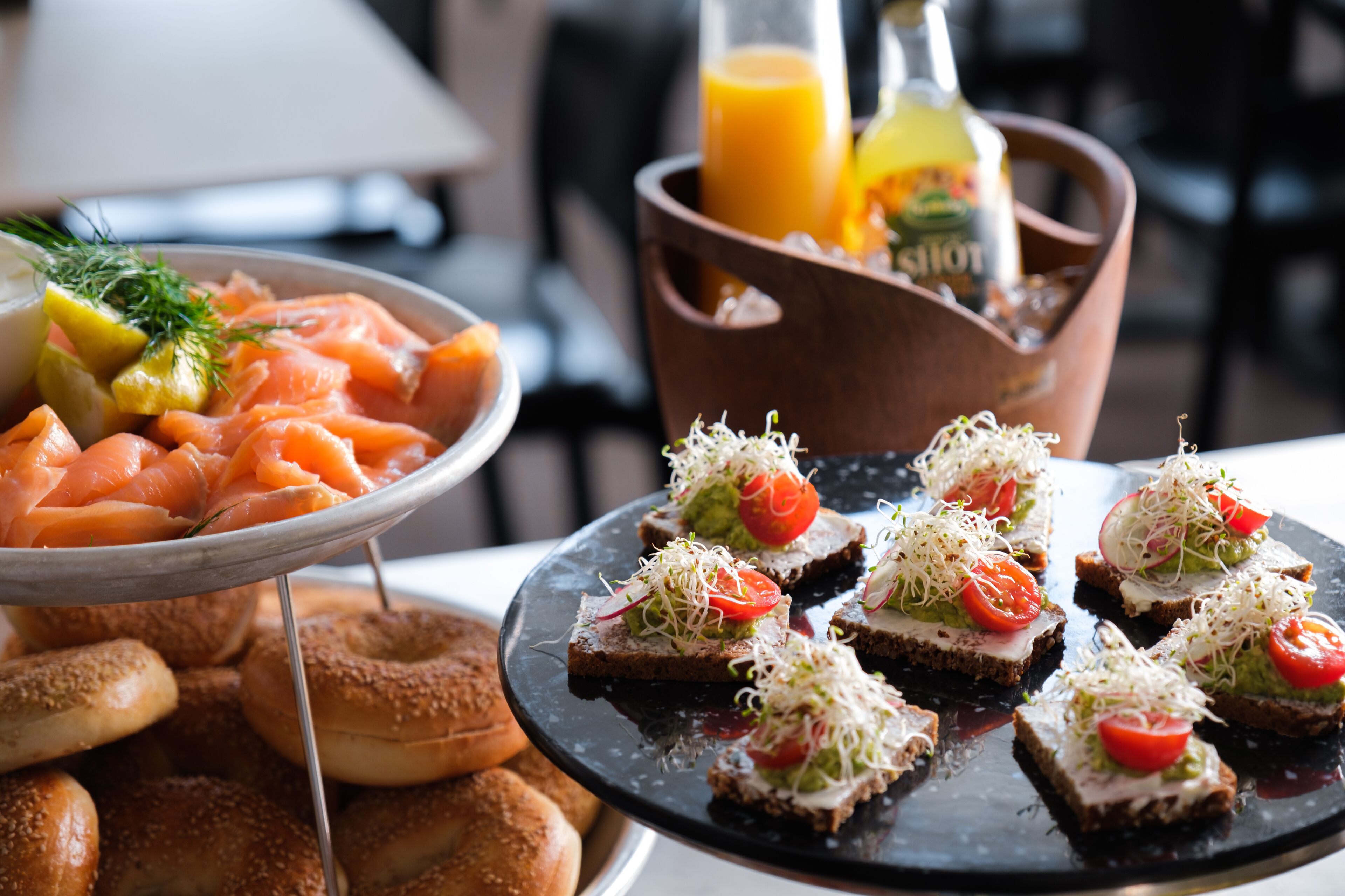 Un bufé con salmón, bagels y una variedad de aperitivos.