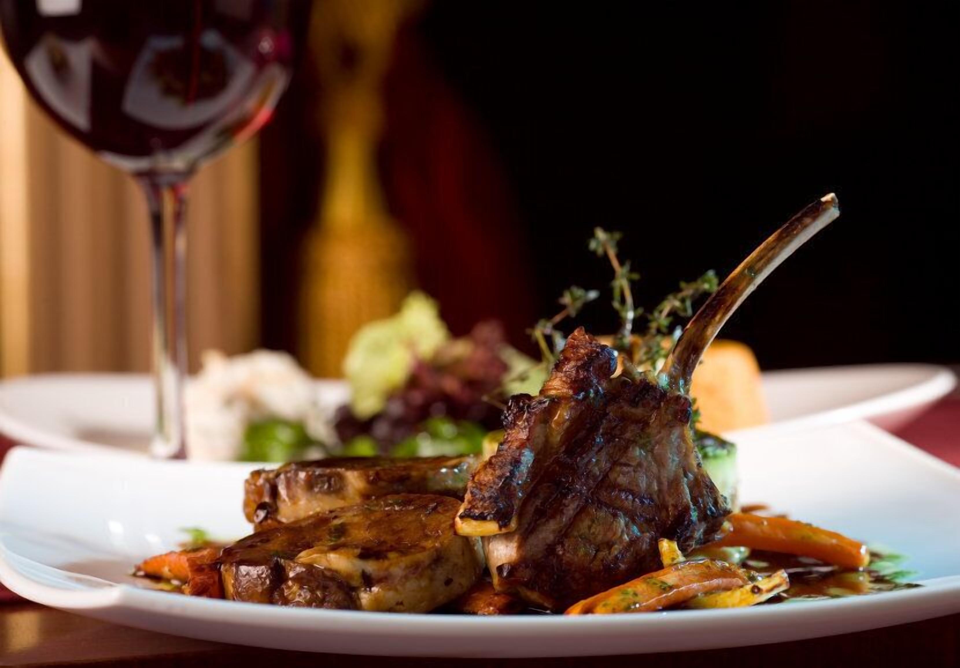 A plate of food with a glass of red wine.