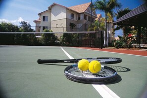 Una cancha de tenis con dos raquetas y dos pelotas.