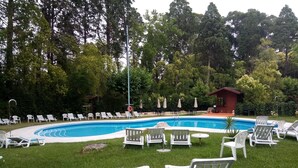 A swimming pool surrounded by white lounge chairs and a small pavilion. - Hotel das Termas Curia (Anadia)