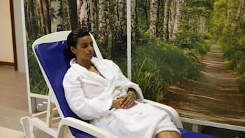 Relax in comfort with a reclining chair in front of a serene forest mural.