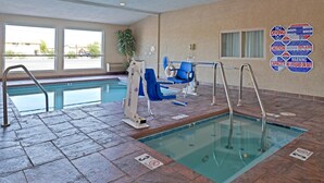 Una piscina coperta con segnaletica chiara, una poltrona per il bagnino e un sollevatore per disabili.