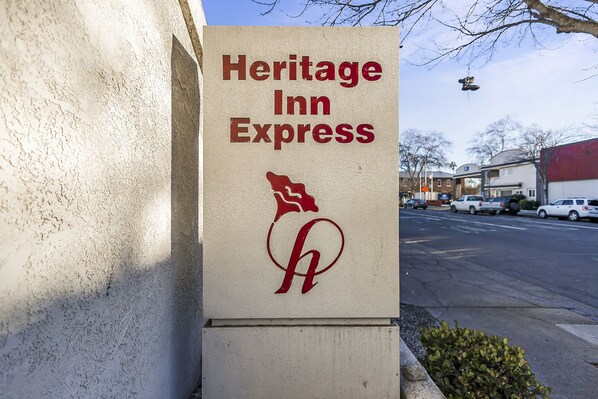 Letrero de Heritage Inn Express, con un logotipo que muestra un caballo estilizado y una 'H'.