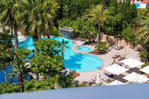 A large outdoor swimming pool surrounded by lush greenery and palm trees. - Albir Playa Hotel & Spa (L'Alfas del Pi)