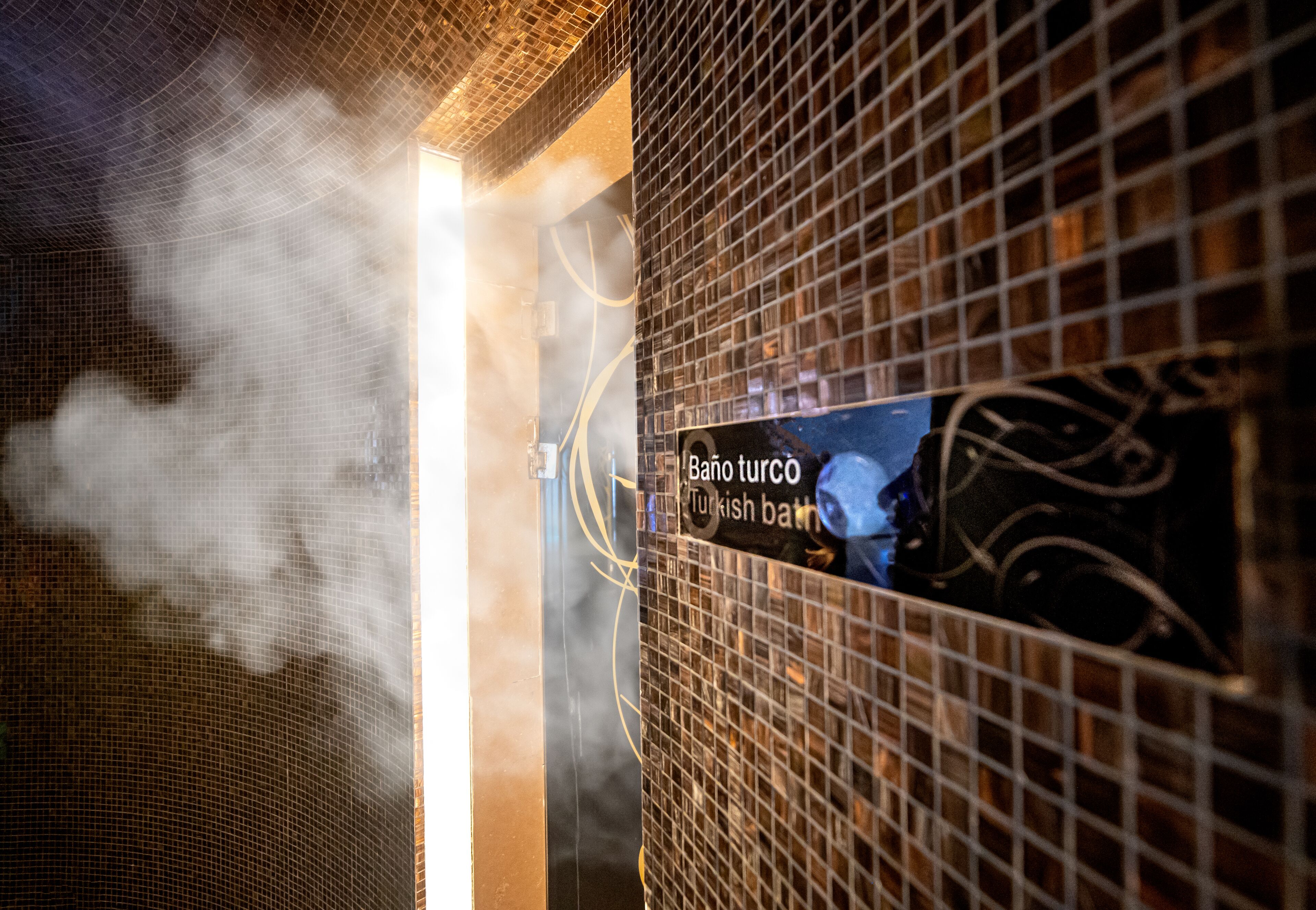 Un baño de vapor con un cartel que dice 'Baño turco Turkish bath'.