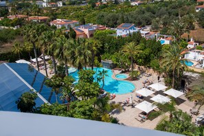 A resort with a large swimming pool surrounded by palm trees and sun loungers. - Albir Playa Hotel & Spa (L'Alfas del Pi)