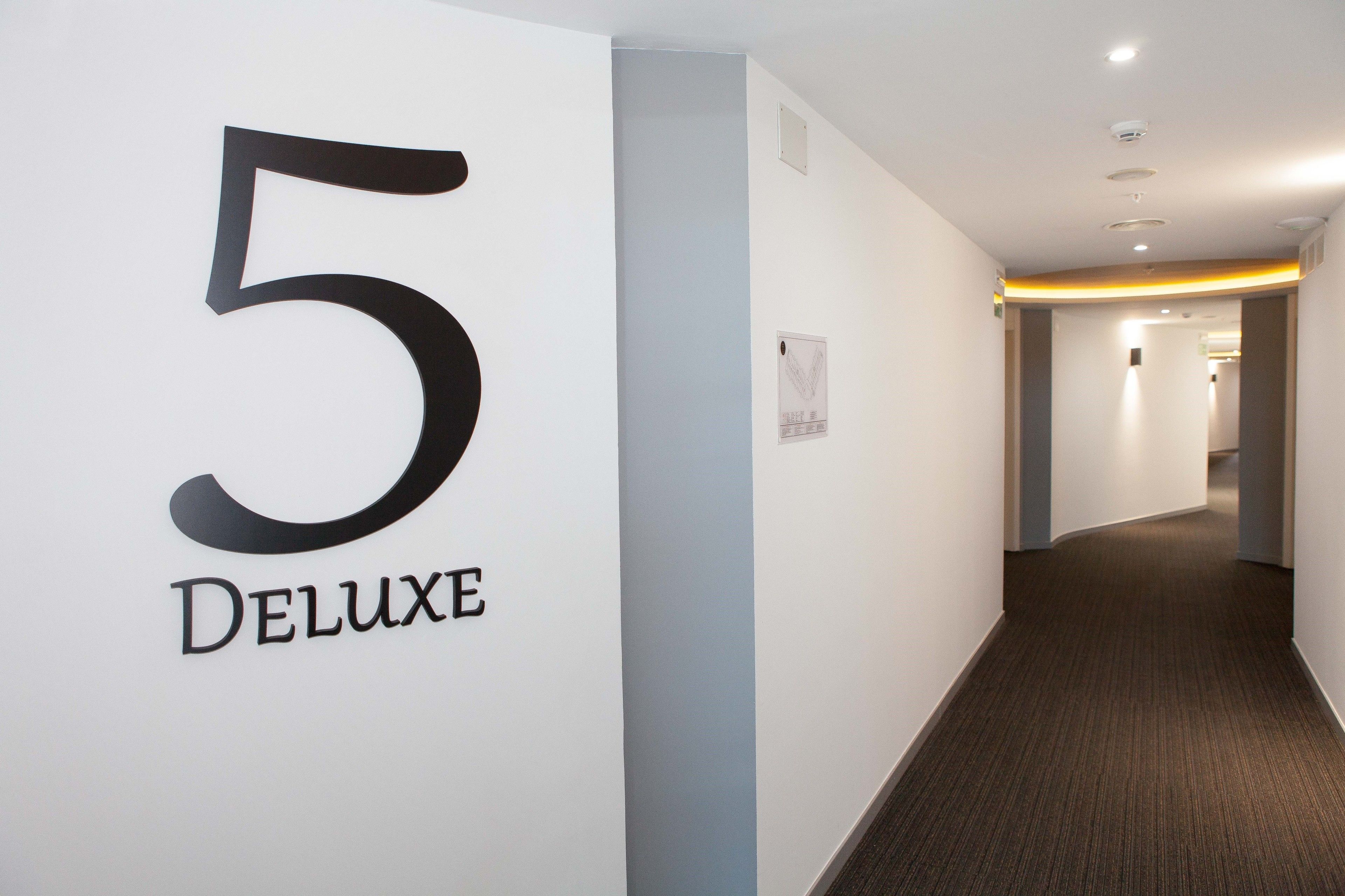 A hallway with a large number '5' and the word 'Deluxe' on the wall, indicating a hotel or property section.