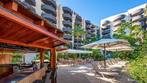 A rooftop bar with outdoor seating and umbrellas, surrounded by a pool area with lounge chairs. - Albir Playa Hotel & Spa (L'Alfas del Pi)