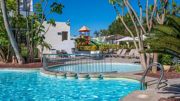 Relax by the pool surrounded by lush tropical vegetation and lounge under the shade of umbrellas.
