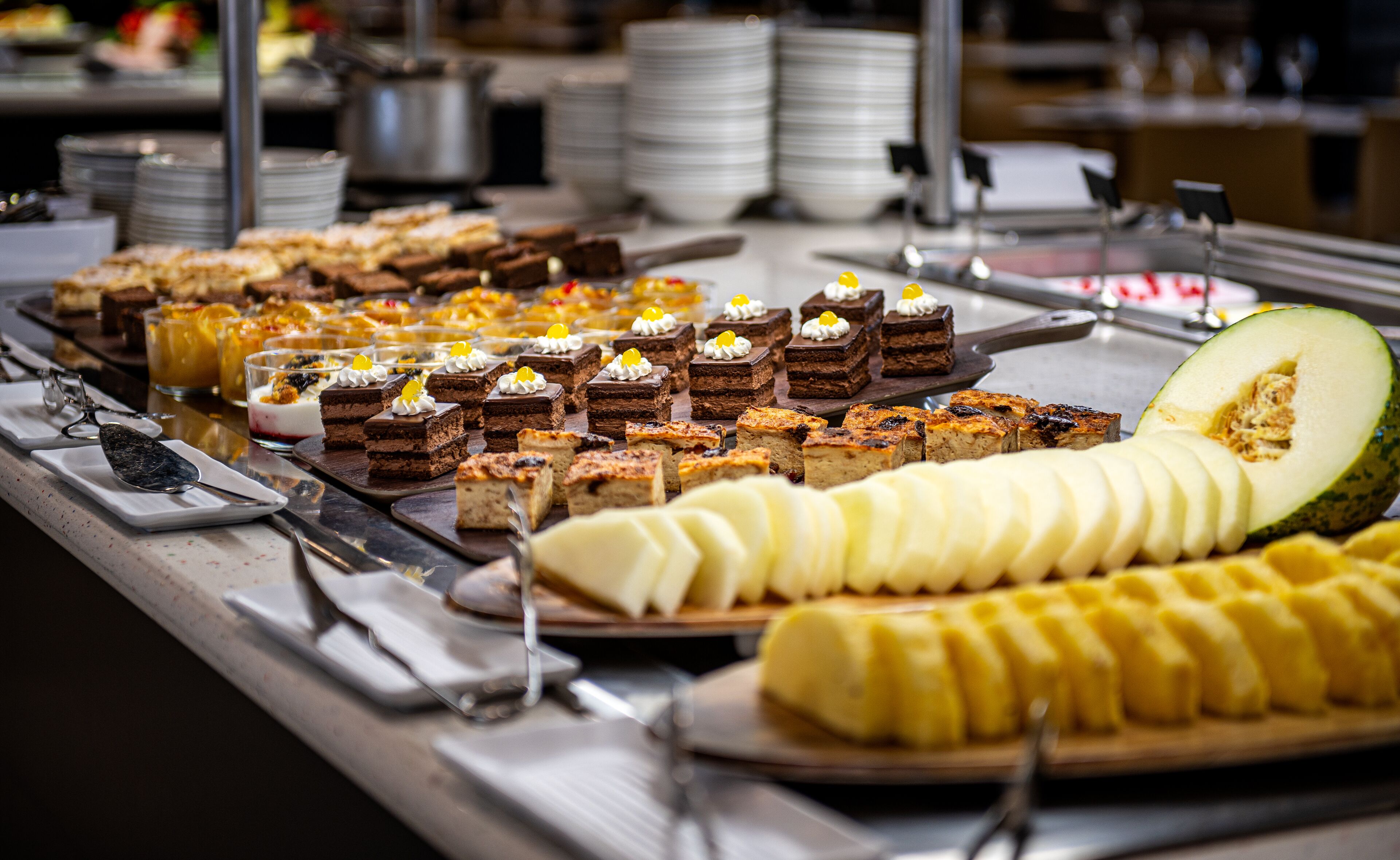 A buffet with various desserts and a sliced melon.
