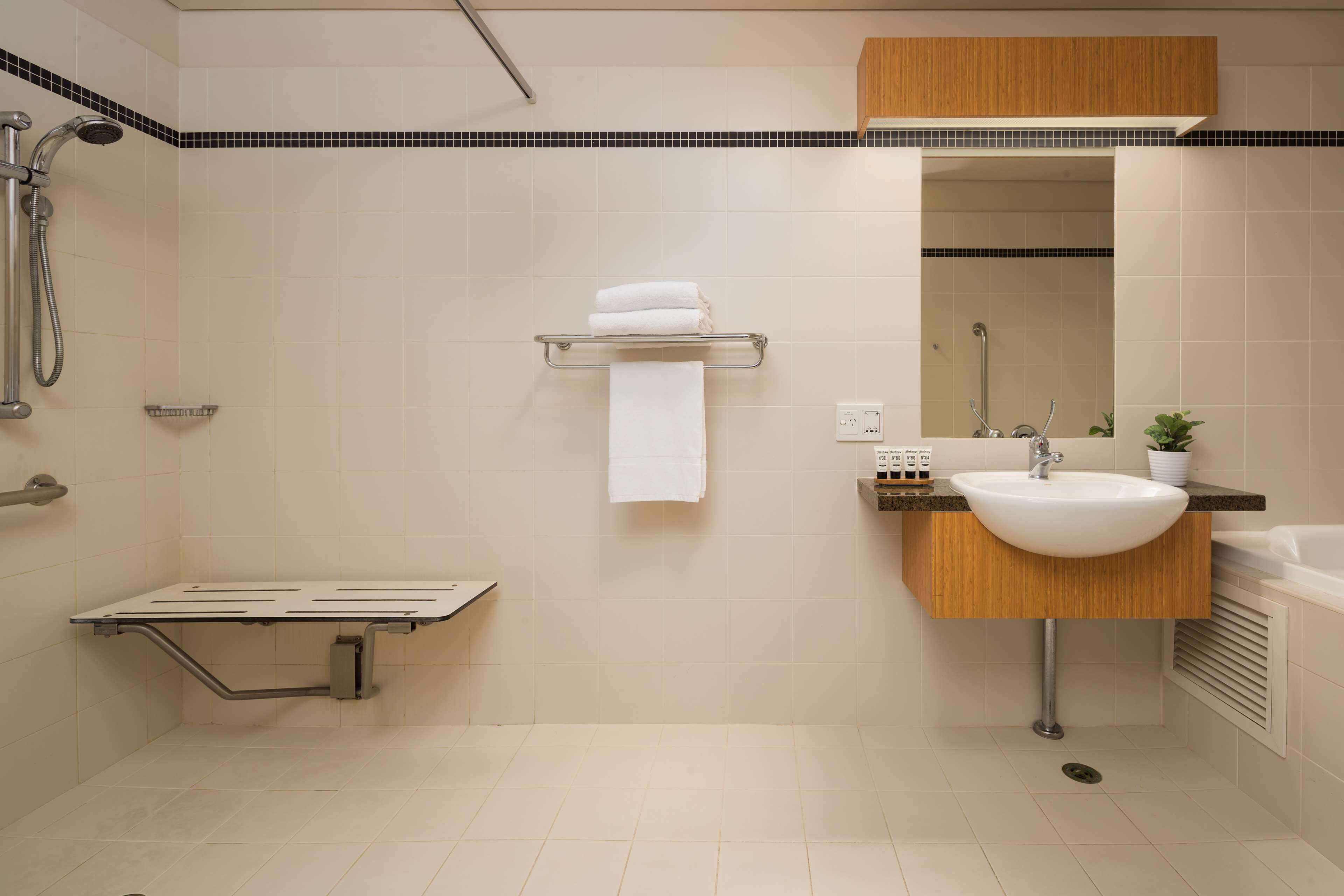 Un bagno moderno con doccia, lavandino e specchio.