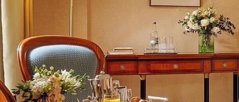 A dining table set with breakfast items, a lamp, and a vase of flowers.