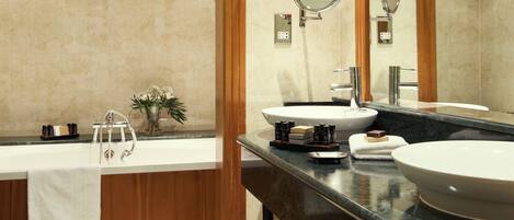 A modern bathroom with two sinks, a large mirror, and a shower area.