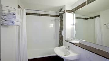 Une salle de bain moderne avec une douche, un lavabo et un miroir.
