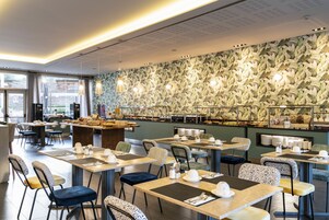 Un restaurant proposant un buffet, avec des tables, des chaises et un mur décoré de motifs.