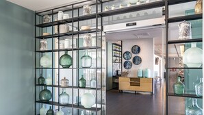 A modern interior with glass display shelves and a wooden cabinet. - Hotel Vincci Maritimo (Barcelona)