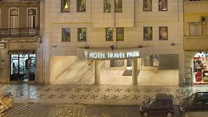A hotel with a modern facade, multiple floors, and a prominent sign indicating it is a hotel and travel park.