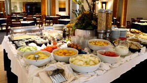 A buffet with various food items and utensils.