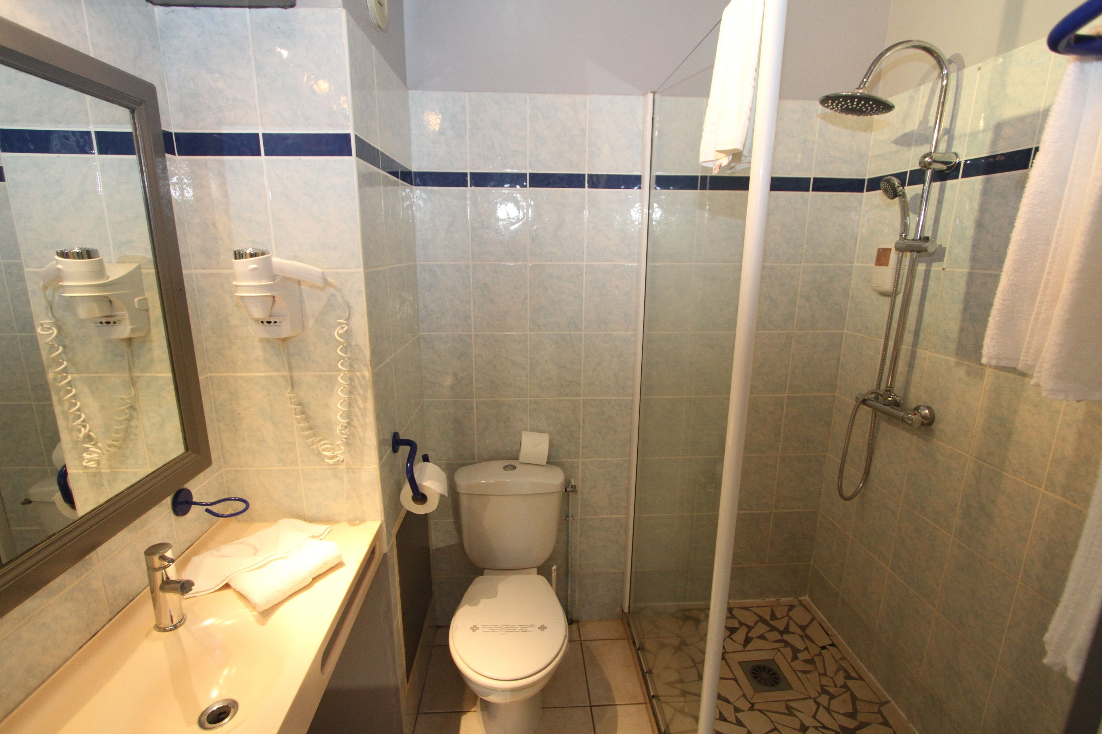 A bathroom with a toilet, sink, and shower.