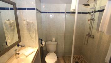 A bathroom with a toilet, sink, and shower.