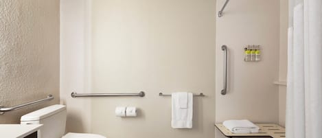 A bathroom with a toilet, a shower, and a sink.