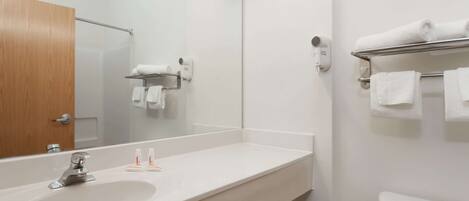 A bathroom with a white sink, a mirror, a towel rack, and a toilet.