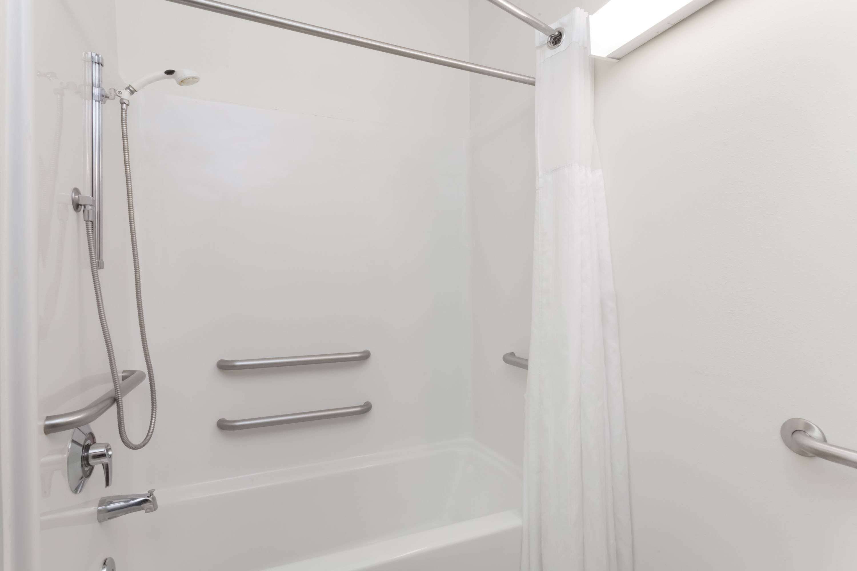 A modern shower area with a glass door, a showerhead, and a handheld shower attachment.