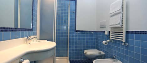 Une salle de bain équipée d’une douche, d’un lavabo, de toilettes et d’un bidet.