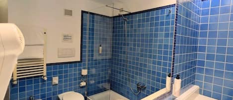 A bathroom with a large mirror, a bathtub, a sink, and a toilet.