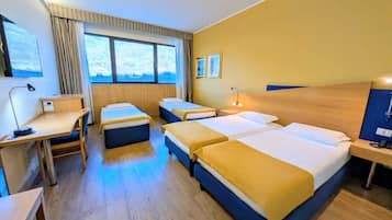 A hotel room with two single beds, a desk, a chair, a small table, a nightstand, and a window with curtains.