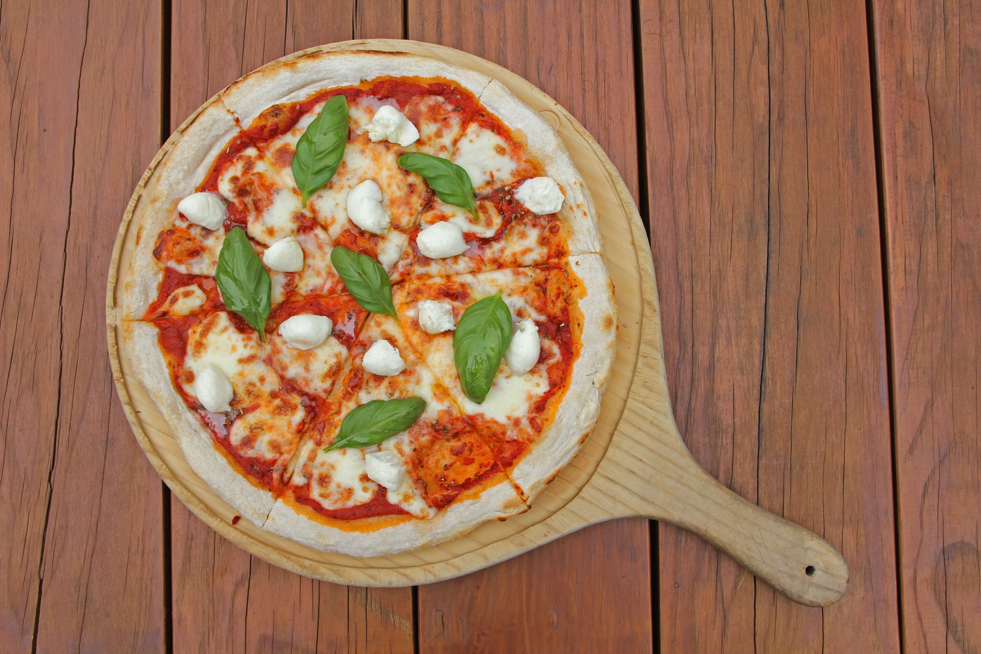 Une pizza sur une planche en bois.