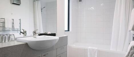 A modern bathroom with a large sink, a bathtub, and a shower.