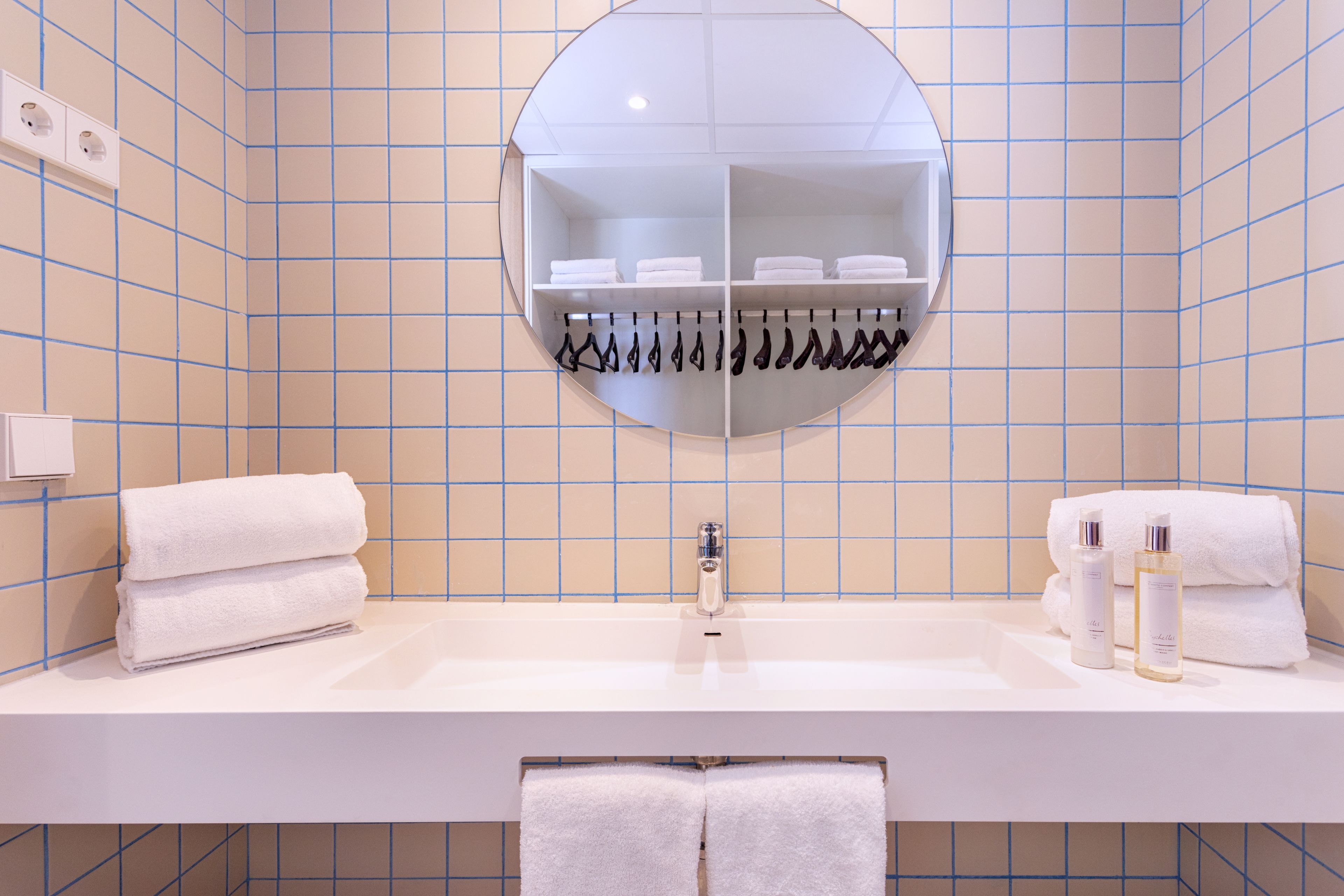 A bathroom with a white sink, a mirror, and a towel rack.