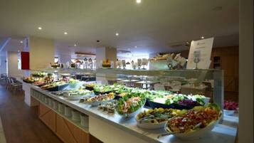En buffet med et bredt udvalg af mad, herunder salater, frugt og andre retter.