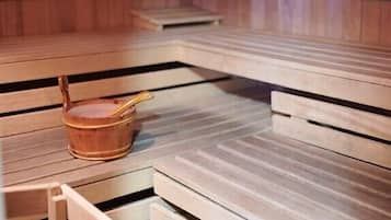 Un sauna en bois avec des bancs et un petit seau en bois.