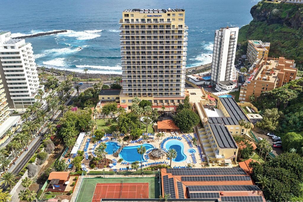 Un hôtel de grande hauteur doté de nombreux balcons offrant une vue sur une plage et l’océan.