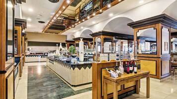 A well-lit, spacious hotel lobby with a central reception desk, multiple seating areas, and a mezzanine level with a view of the lobby.